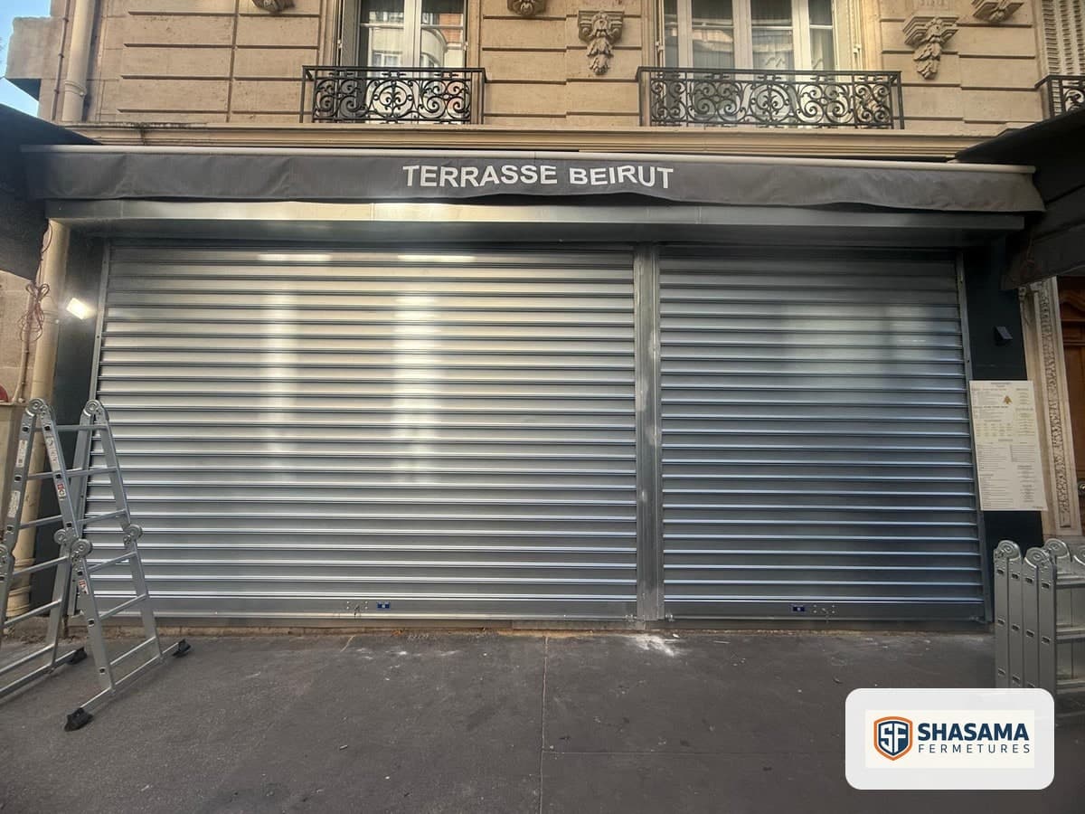 Rideau métallique à lames pleines galvanisées fermé sur les deux travées d’une devanture