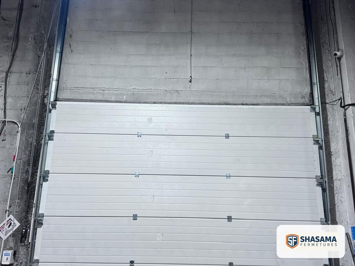 New industrial sectional door in the closed position, viewed from inside the warehouse