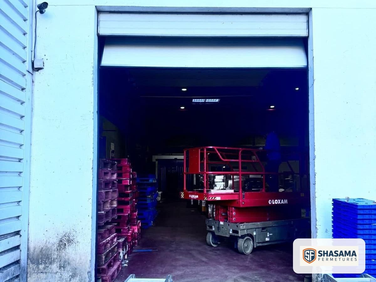 New industrial sectional door raised at the entrance to a logistics warehouse, viewed from outside