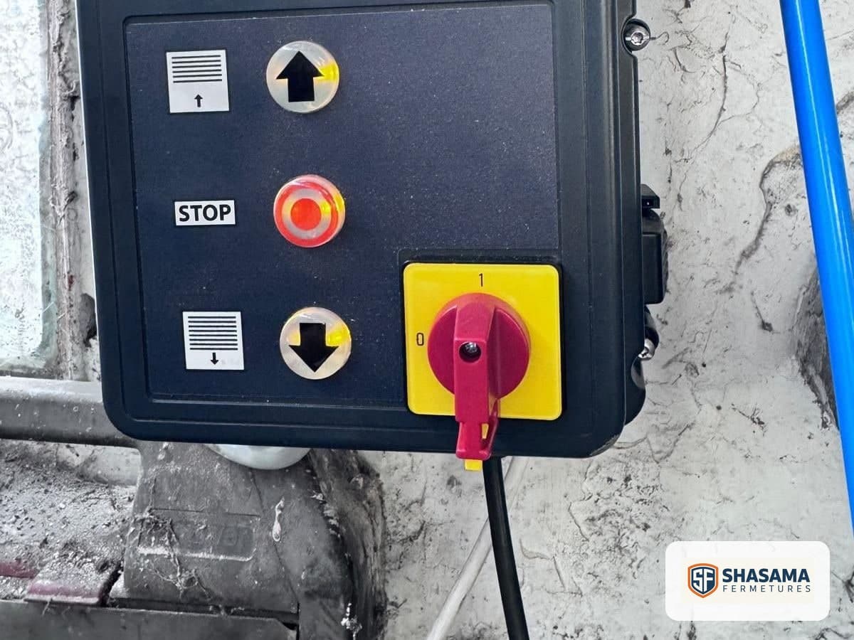 Up, stop and down buttons on the wall-mounted controls for a motorised industrial sectional door