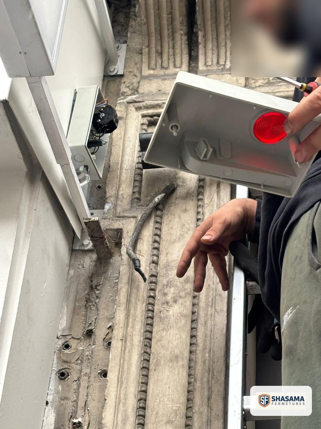 Contrôle manuel du mécanisme d’un rideau métallique, voyant rouge allumé sur le boîtier de test