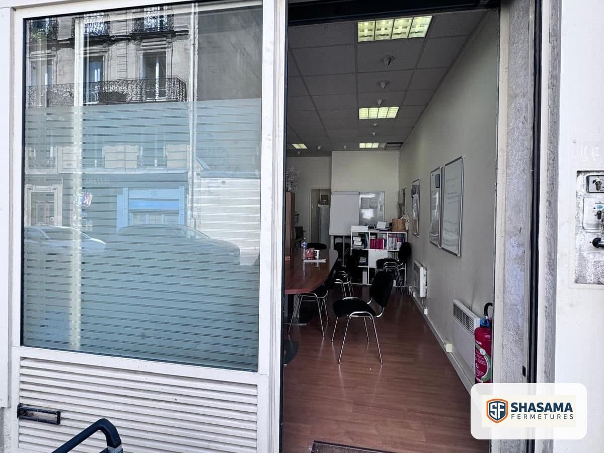 Devanture vitrée ouvrant sur une salle de réunion avec table et chaises