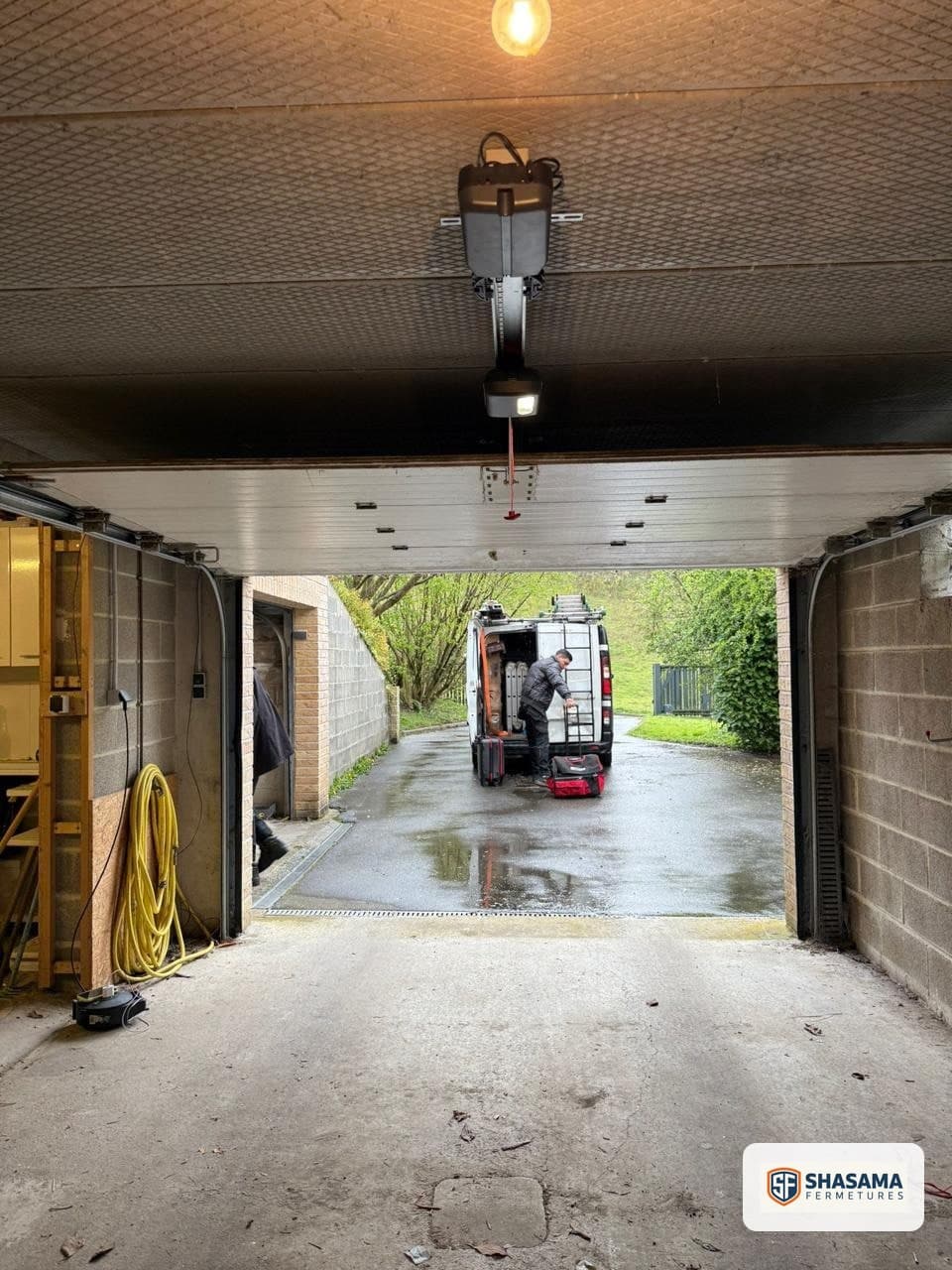 Vue intérieure de la porte sectionnelle ouverte, rail de guidage et bloc moteur installés au plafond du garage