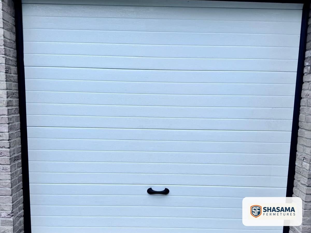 New sectional garage door closed within its brick surround, seen from outside the garage